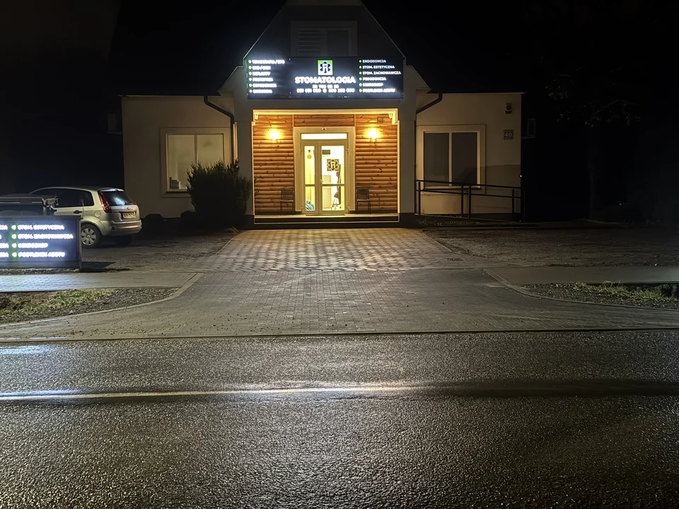 Oświetlone wejście do AKODent wieczorem