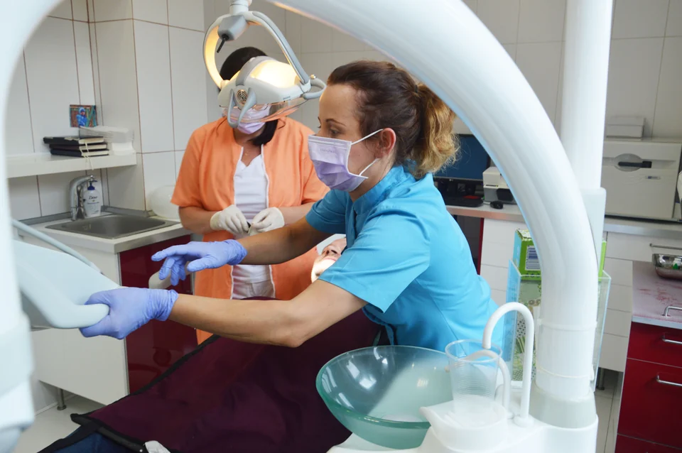 Zespół AKODent przy ekranie obok fotela z Pacjentem